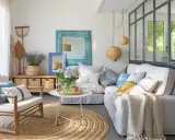 Ideas para decorar casa playa poco presupuesto: sofá blanco, alfombra de yute, cestas de mimbre y detalles marineros.