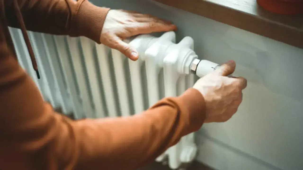Manas ajustando el termostato para limpiar radiadores y optimizar la calefacción.