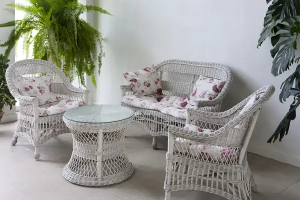 Conjunto de muebles de mimbre blanco con cojines florales, ideal para restaurar muebles de mimbre y darles un toque fresco.