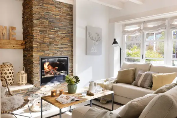 Acogedor salón moderno con chimenea de leña, sofá beige y mesa de centro de madera.